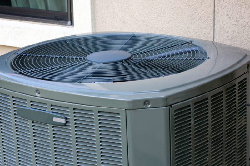 A closeup picture of the top fan of an outside air conditioning unit