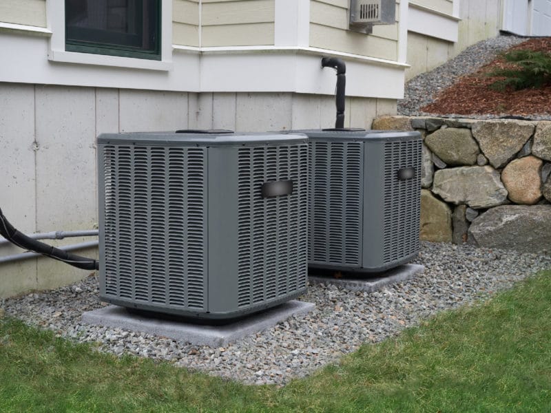 A picture of two air conditioning units outside of a residential home