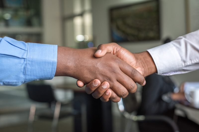 Close view of two men's hand shaking on a business deal.