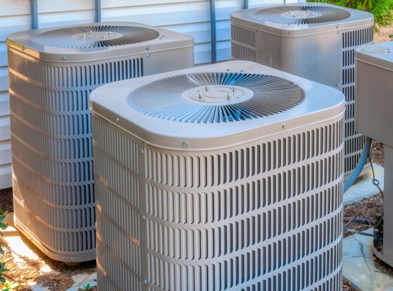 A group of 3 air conditioning units outside all clean and properly maintained